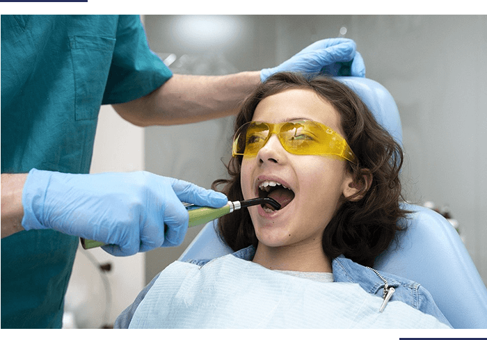 A woman is getting her teeth cleaned by an dentist.